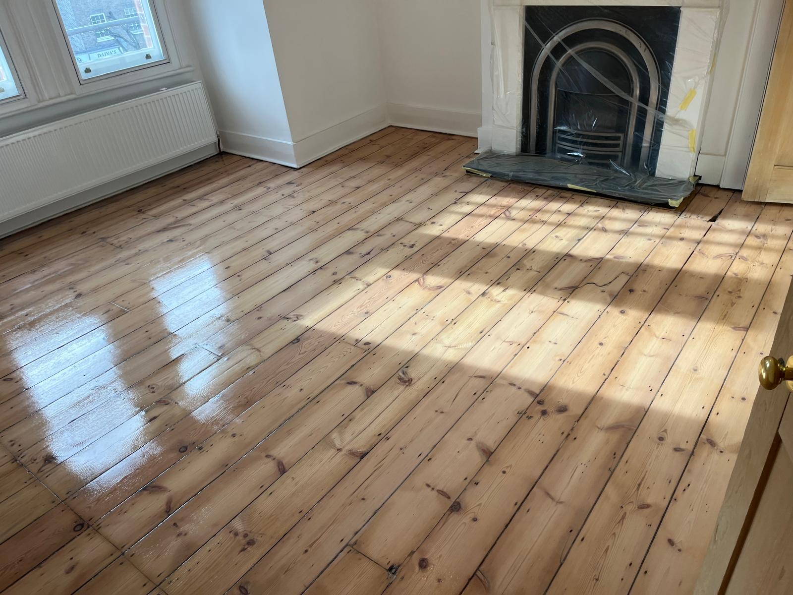 Wood Floor Sanding in Hounslow showing restored original solid pine floorboards in a living room with a smooth, freshly sealed finish and natural timber grain.