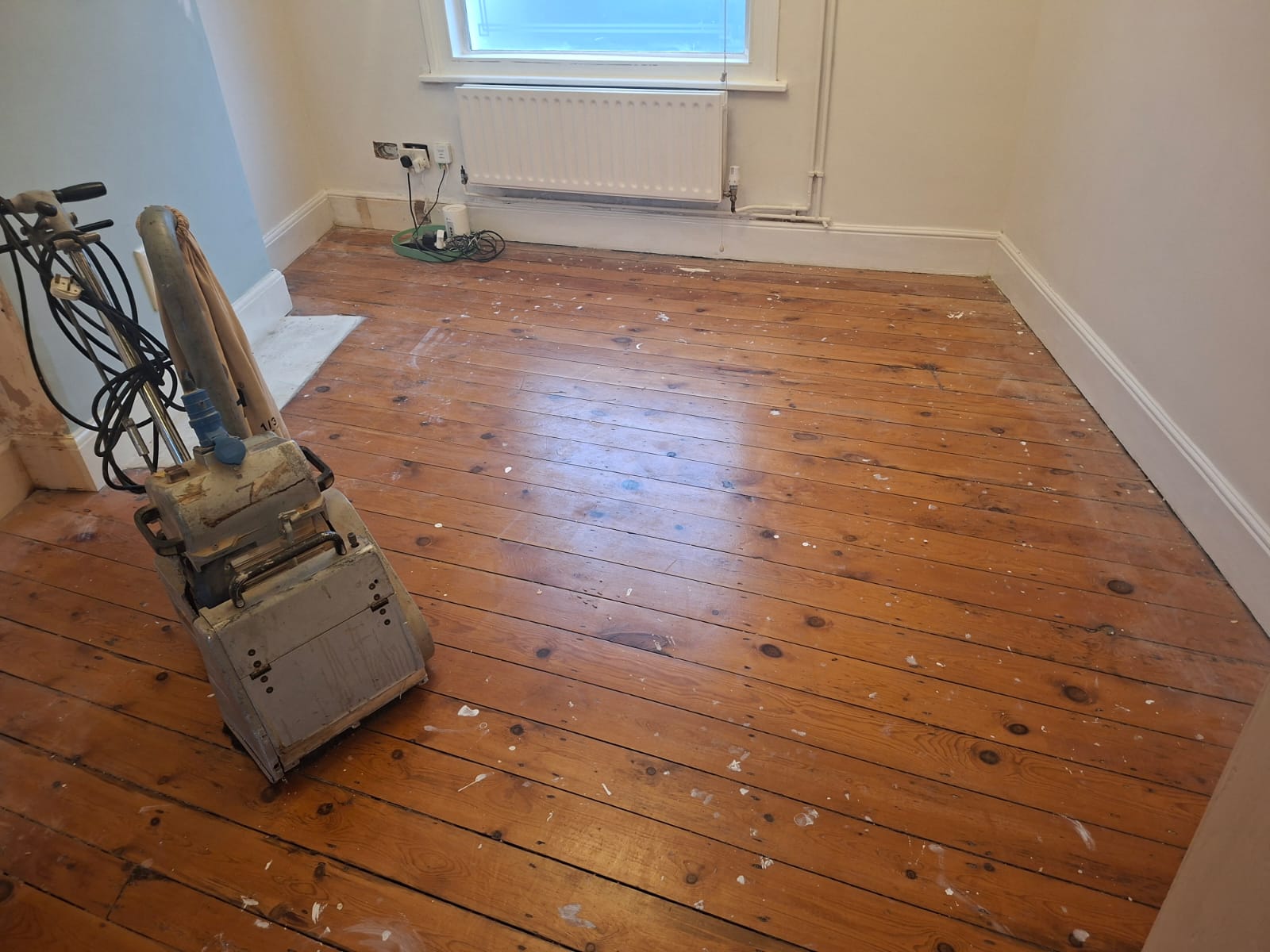 Wood Floor Sanding in Hounslow on an original pine bedroom floor with visible boards being restored using a professional floor sander.