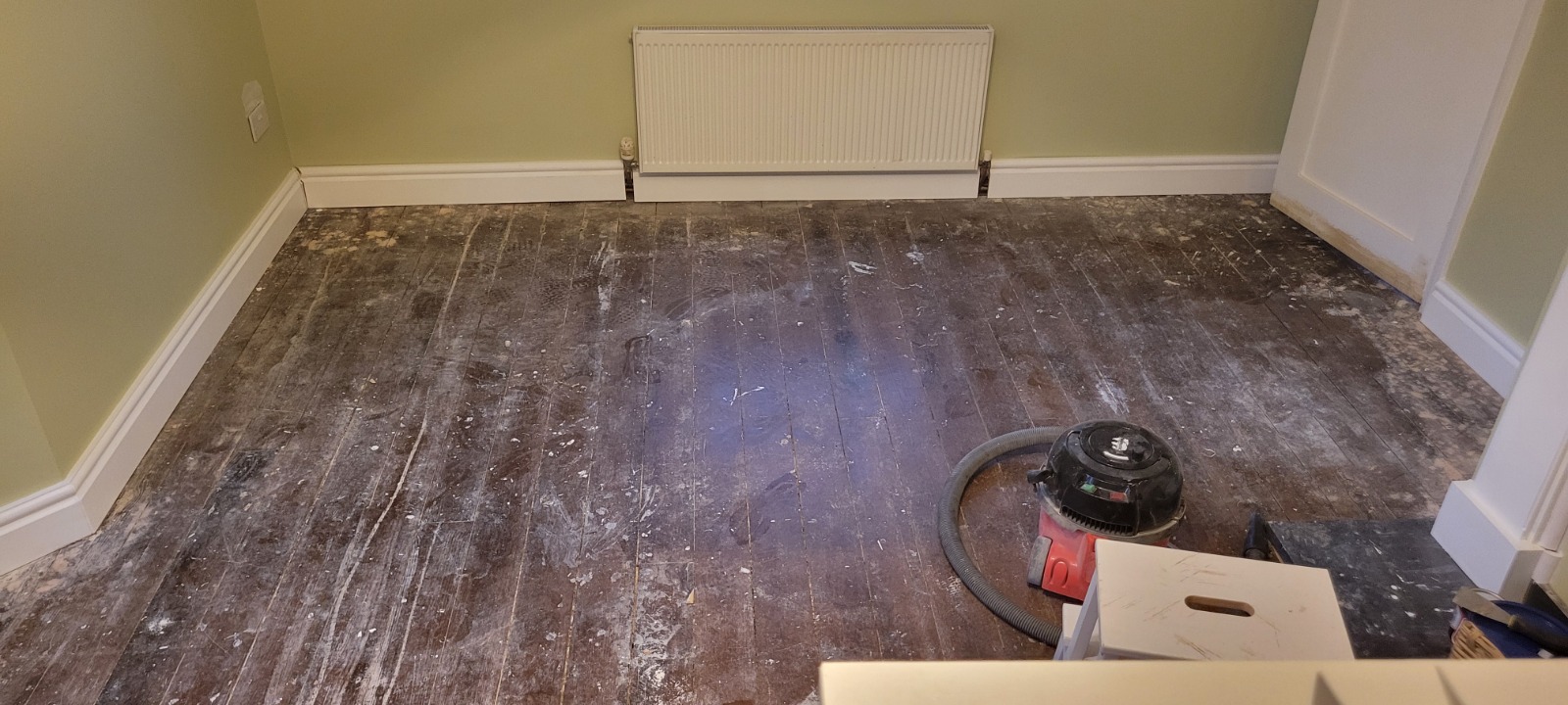 Wood Floor Sanding in Hounslow showing worn hardwood floorboards in a room, with surface marks and dust ready for professional sanding and refinishing.